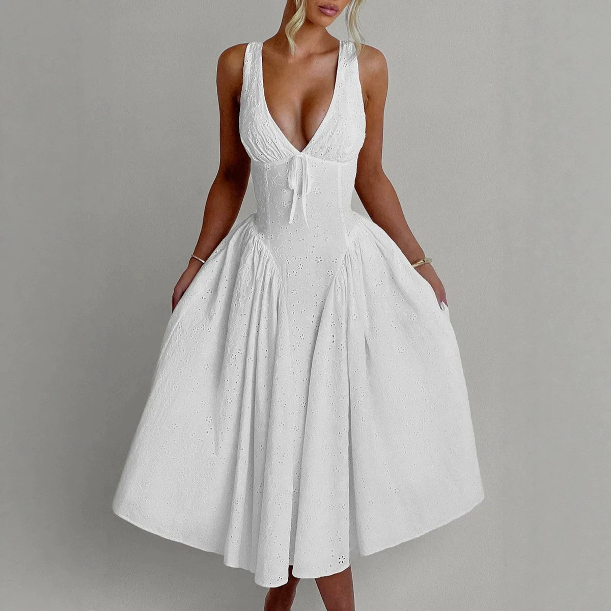 White sleeveless V-neck dress with gathered skirt and bow-tie detail at the waist