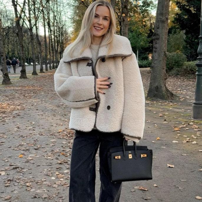 Beige plush fur long-sleeve coat with black-trim lapels and button front.