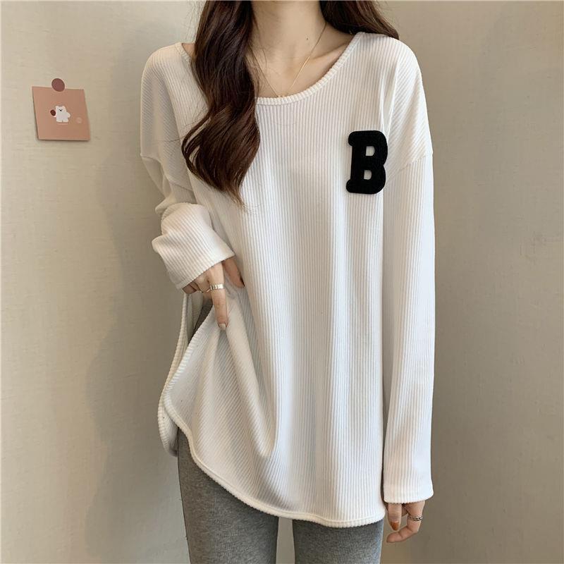 White long-sleeve base top with ribbed knit and black “B” patch on chest