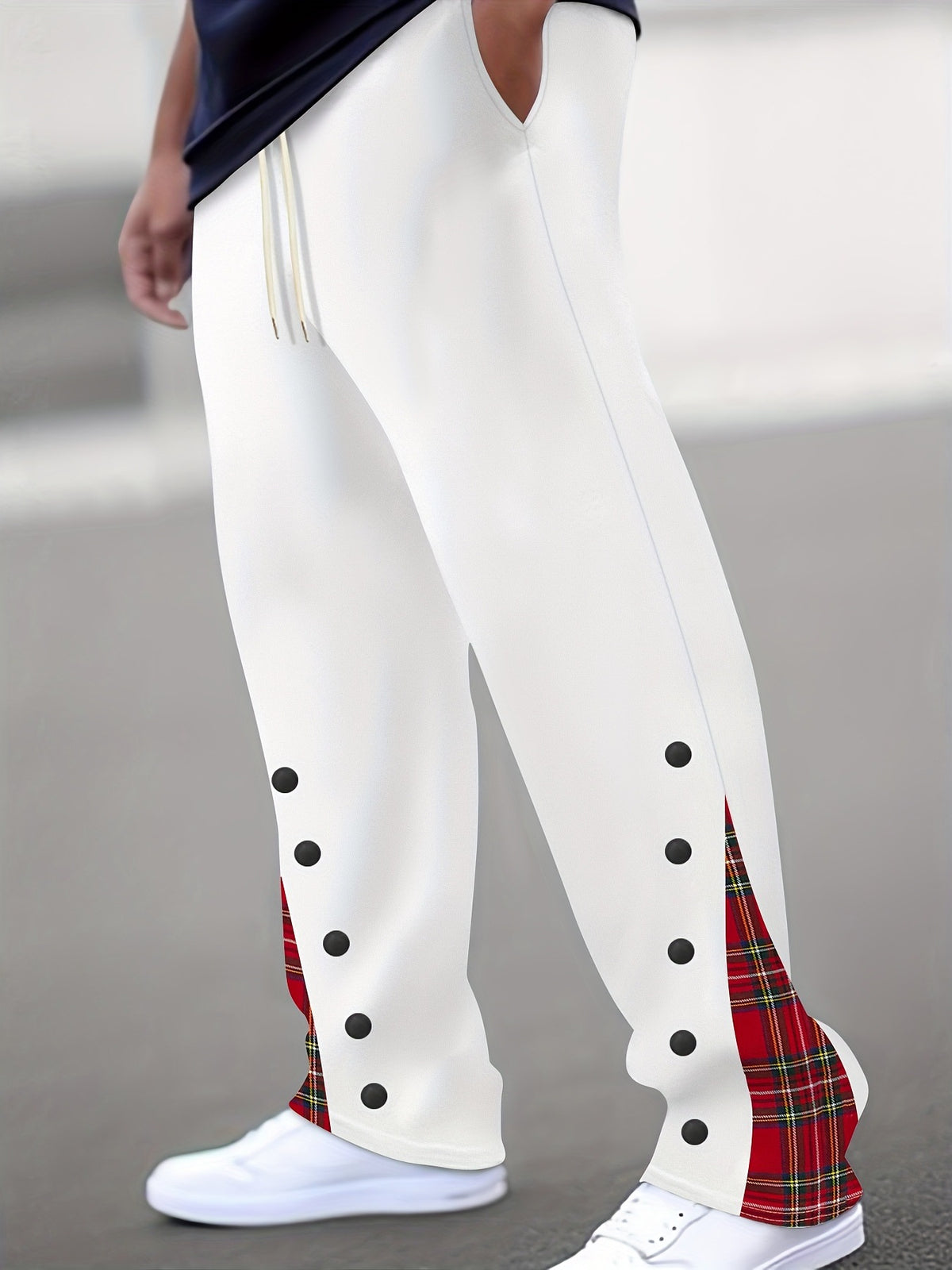 White pants with black button-like dots and red tartan insert on the side