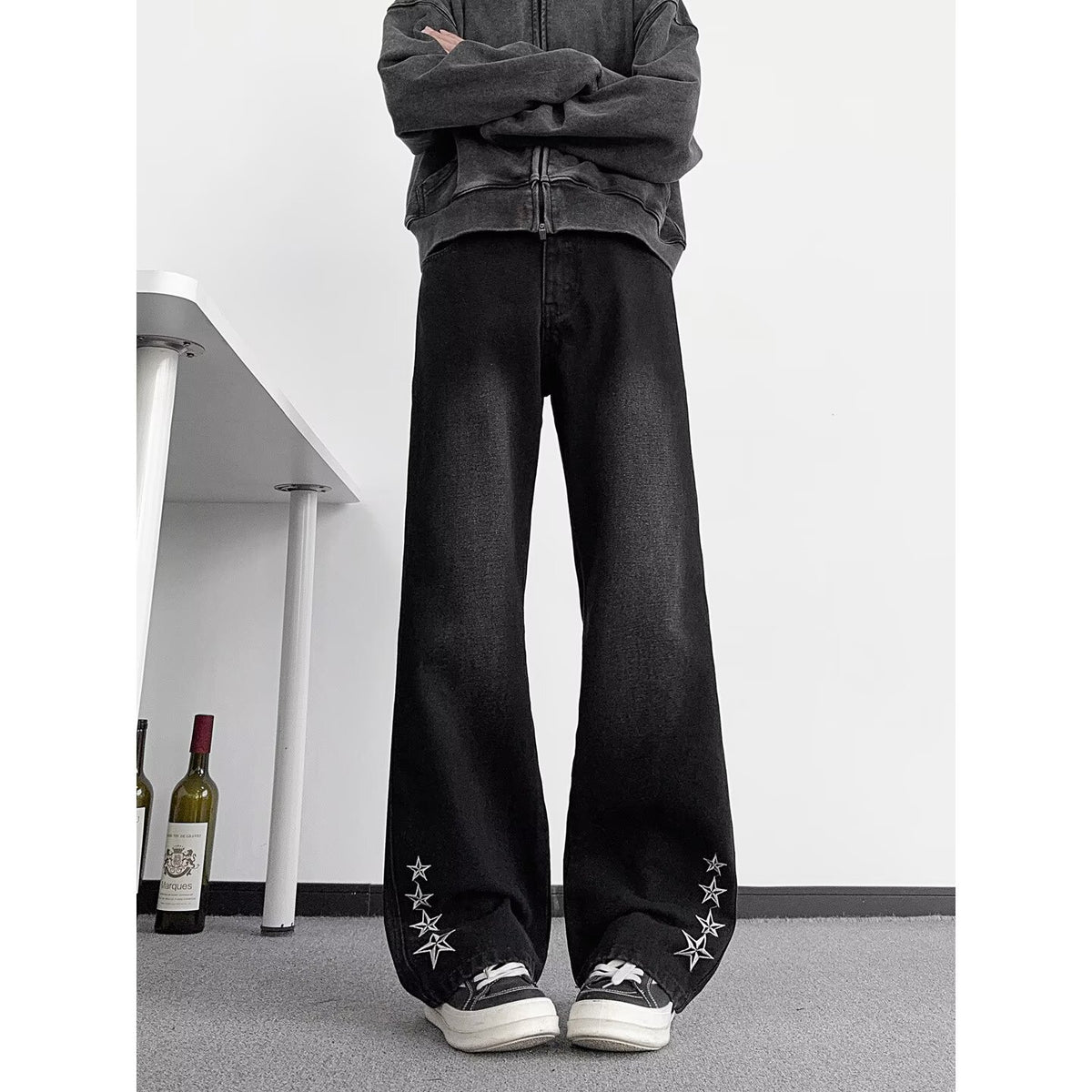 Men's black straight-leg jeans with star embroidery along outer cuff