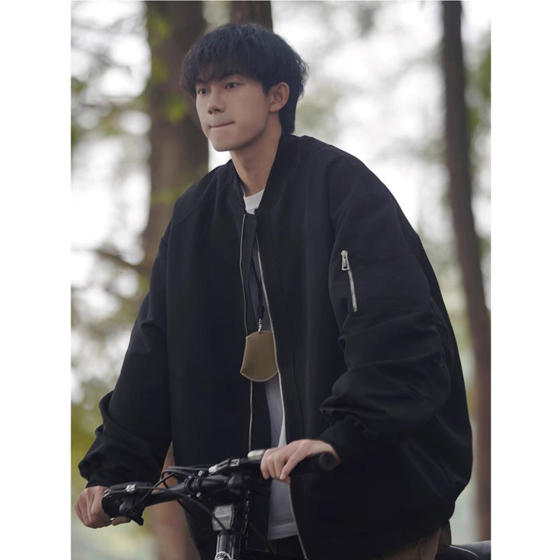 Men's loose pilot jacket in black or very dark navy with zip front and stand collar.