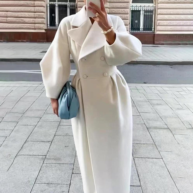 Women’s long winter coat in white with lapel collar, double-button front, and waist belt.
