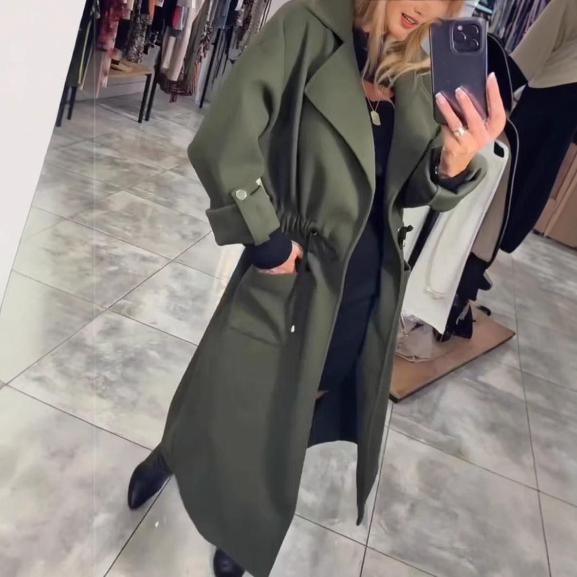 Army green extended-waist trench coat with belt tie, flap pockets, and long sleeves