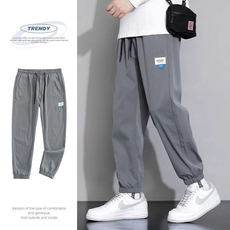 Gray draping sports jogger pants with elastic ankle cuffs and drawstring waist