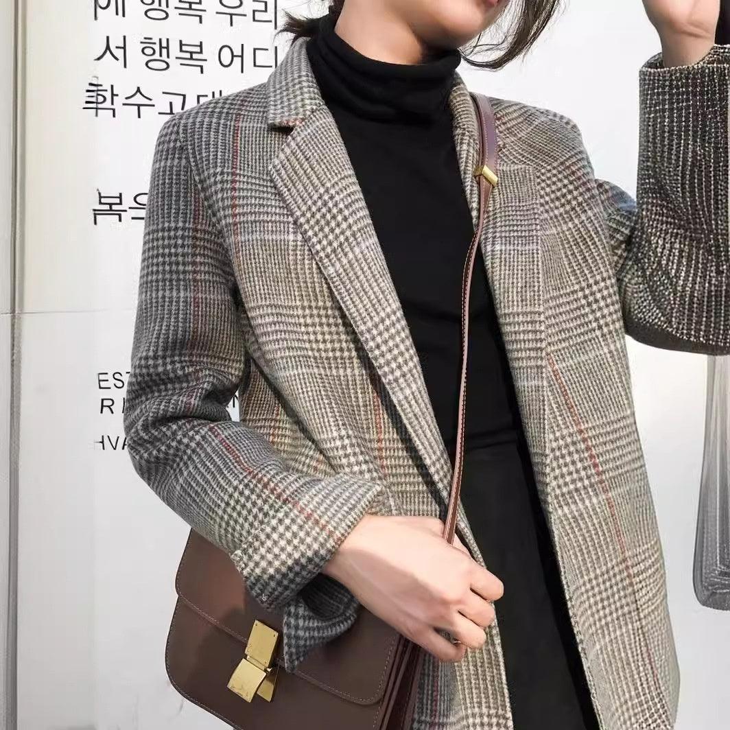 Plaid mid-length wool blazer with lapels, paired with matching shorts over black turtleneck