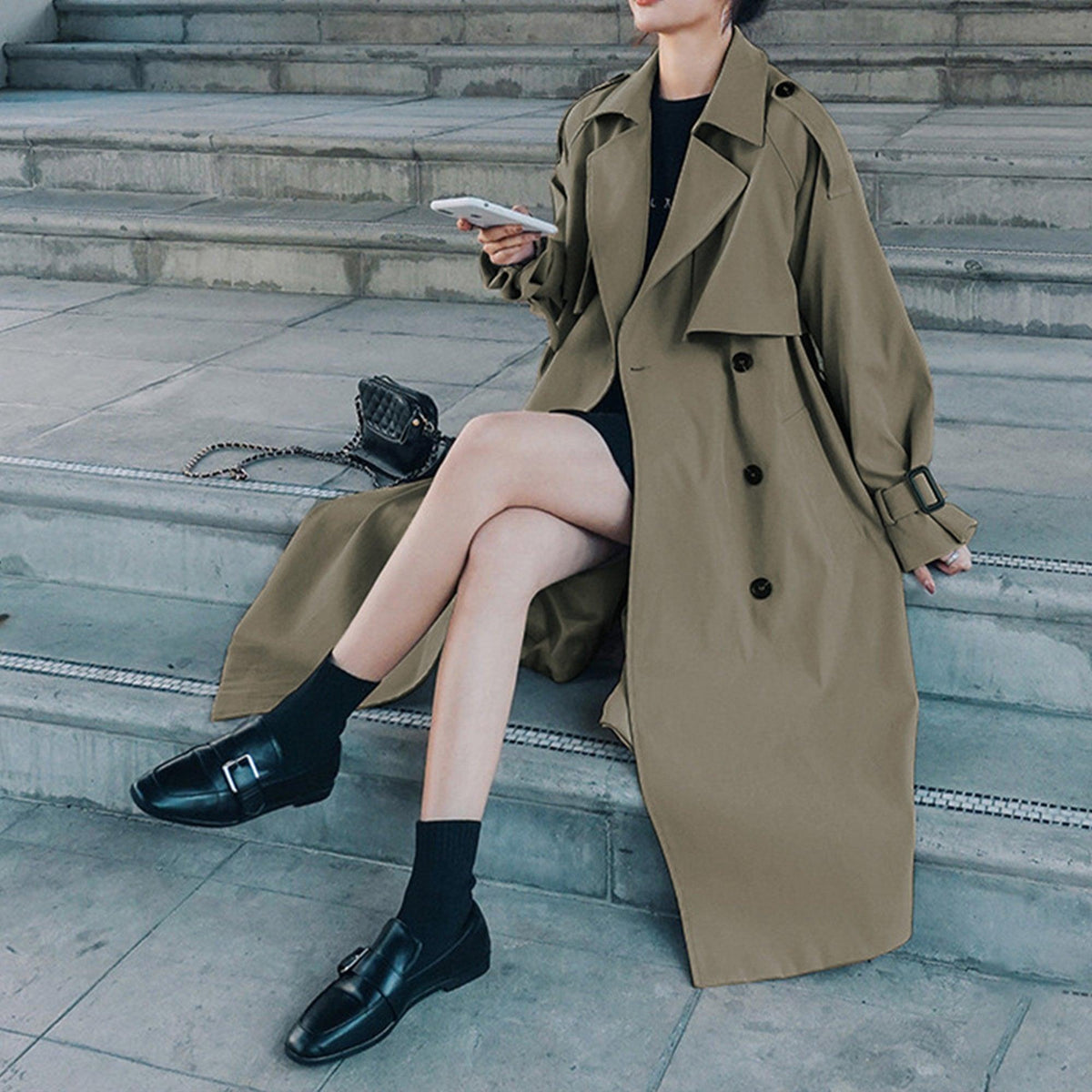 Women’s olive green trench coat with double-breasted buttons and belted waist