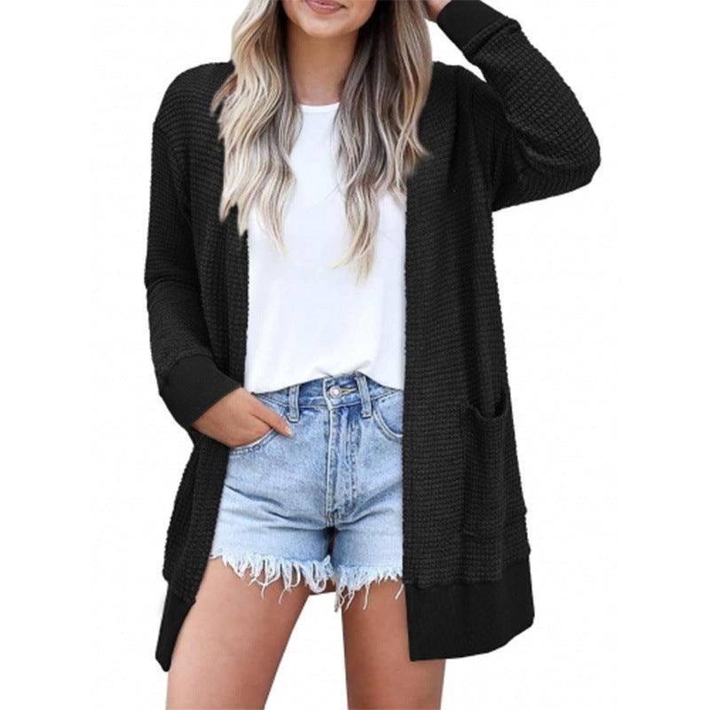 Black knit cardigan with open front and long sleeves, relaxed hip-length