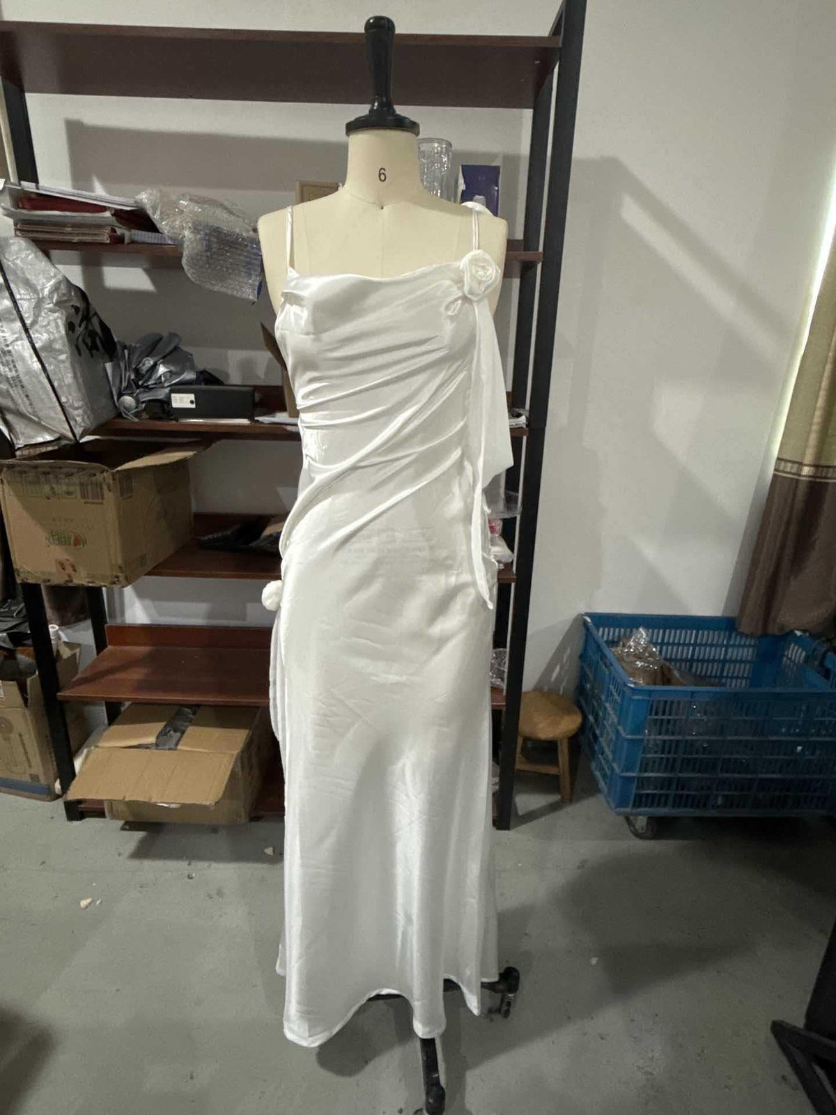 White satin maxi dress on mannequin with spaghetti straps and bow-tied neckline