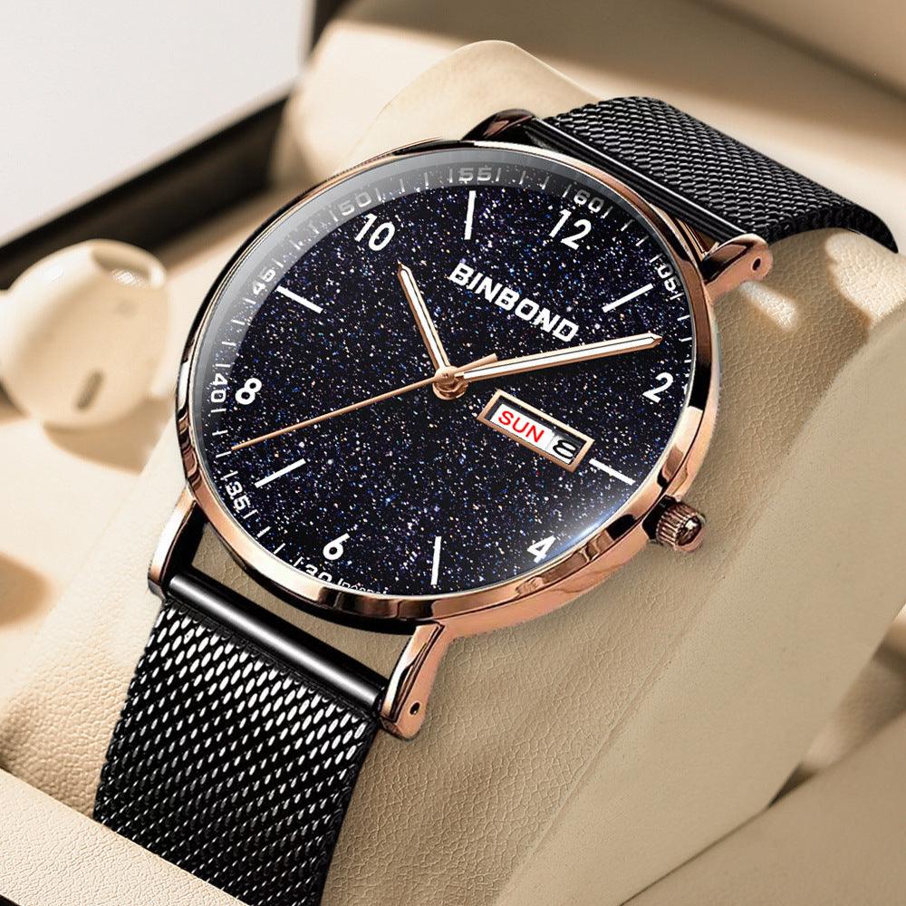 Analog wristwatch with dark blue speckled dial, rose-gold bezel, black mesh strap.