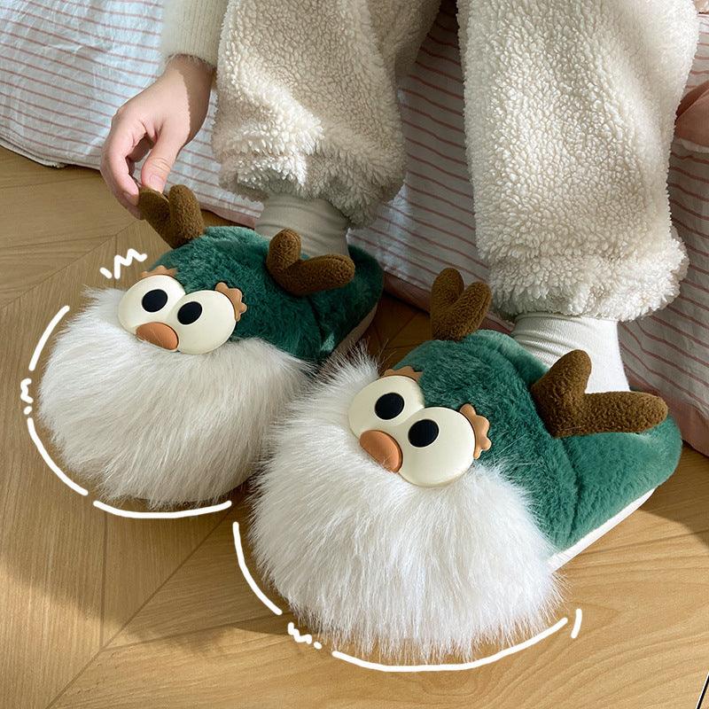 Green cartoon deer slippers with plush white fur, round eyes, and brown antlers on top