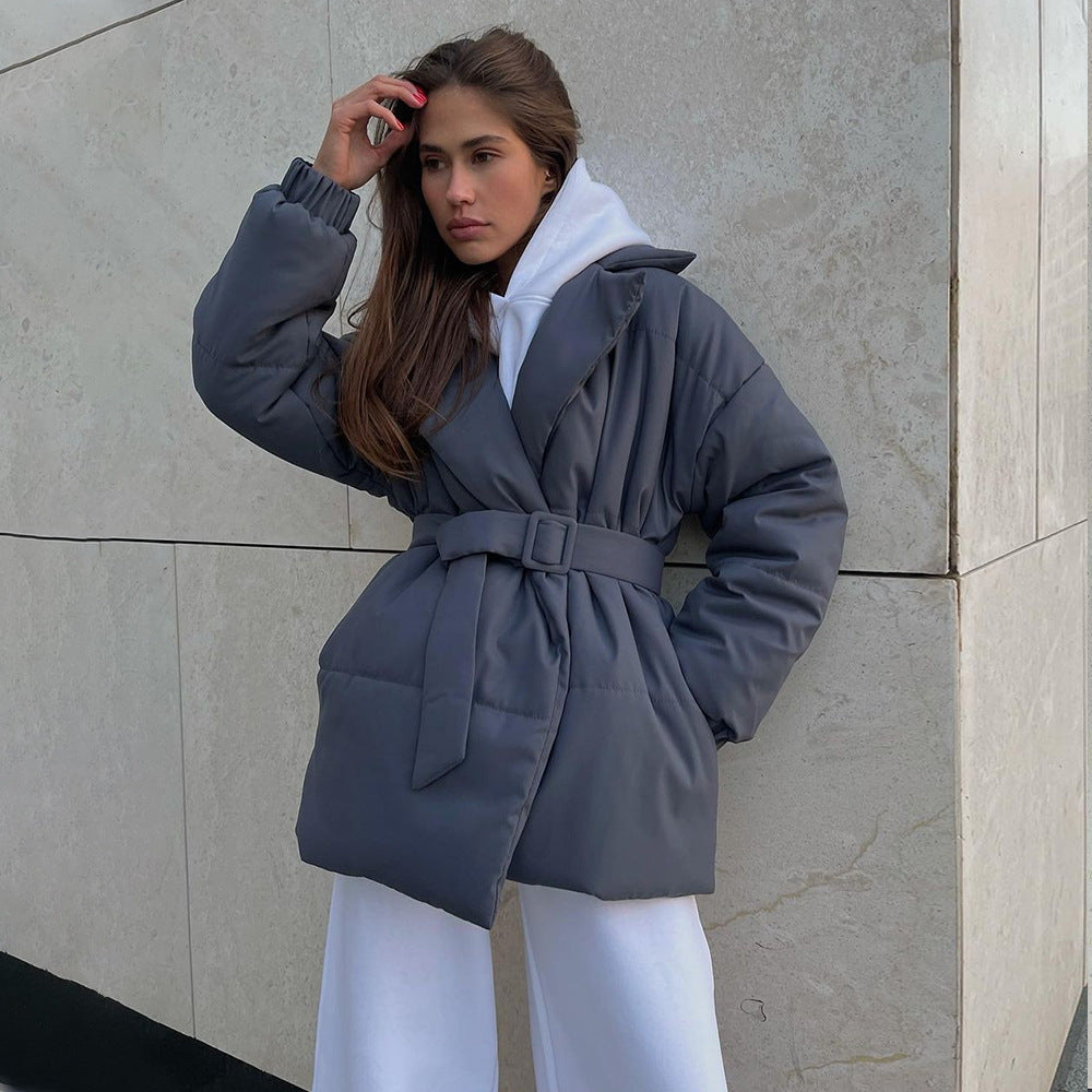 Solid color cotton coat with hood, belted waist, and quilted puffer styling in dark blue-gray