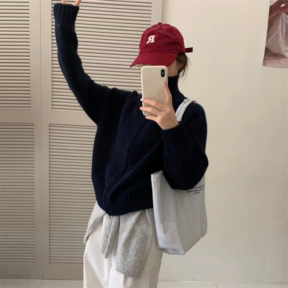 Navy knit short cardigan coat with long sleeves and front closure.