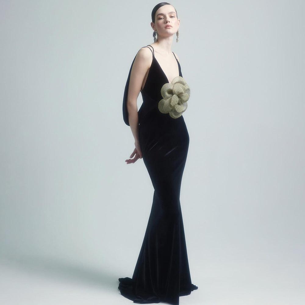 Backless black slim-fit camisole dress with golden flower applique, sleeveless mermaid hem.