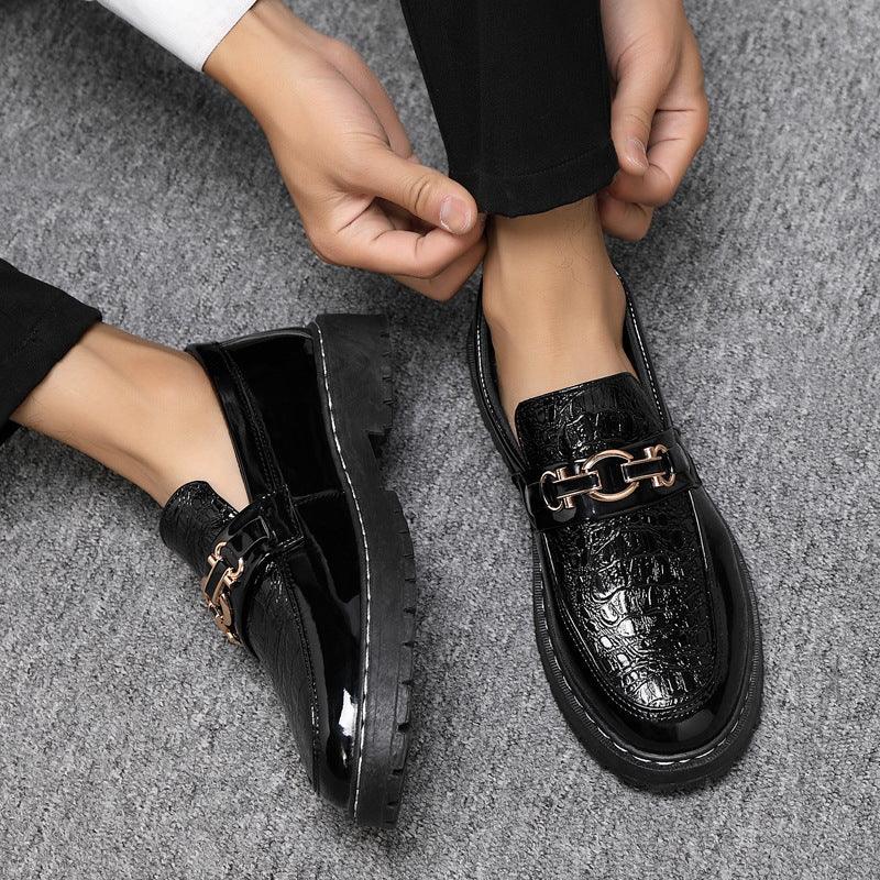Black glossy leather loafers with metal buckle strap and contrast stitched side sole.