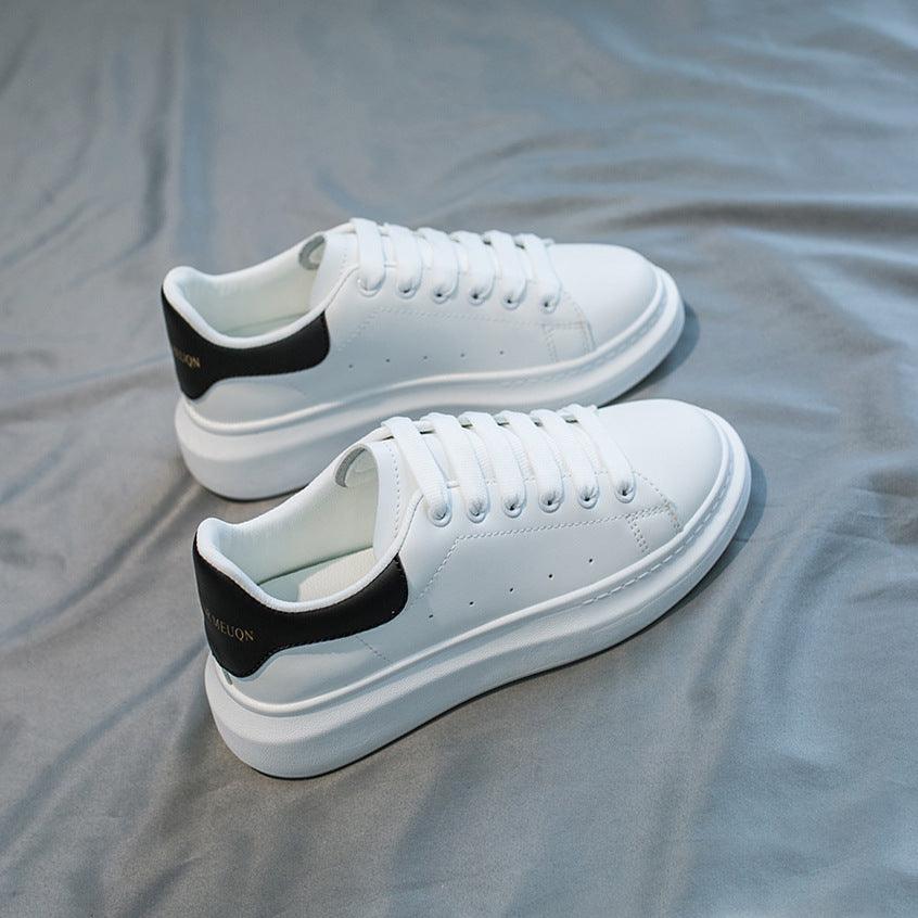 Women's white lace-up platform sneakers with black collar and cushioned sole
