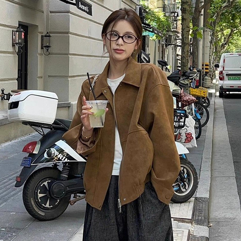 Brown stand-collar loose jacket with zip-front, worn over a white top