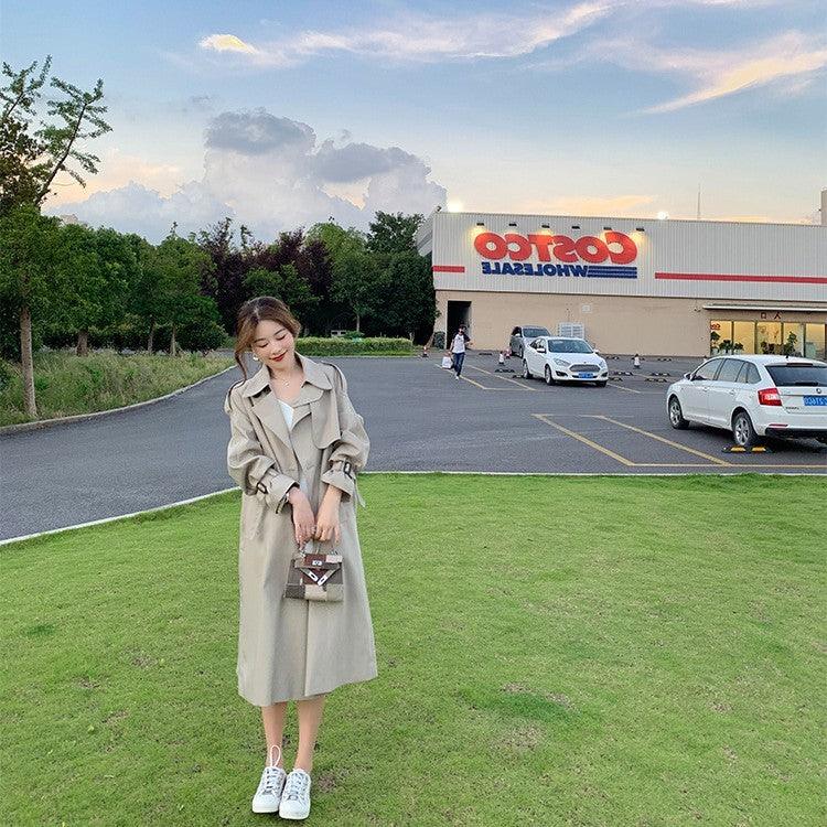 Beige mid-length trench coat with waist belt, notched lapels, button front