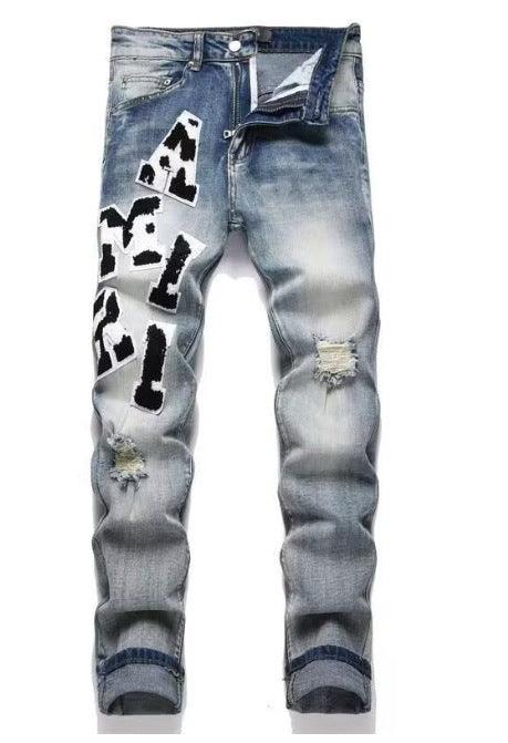 Light wash jeans with black-and-white cow graphic print and distressed patches