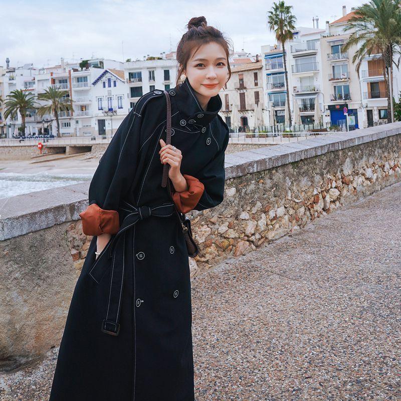Black belted double-breasted trench coat with buttoned cuffs and long length