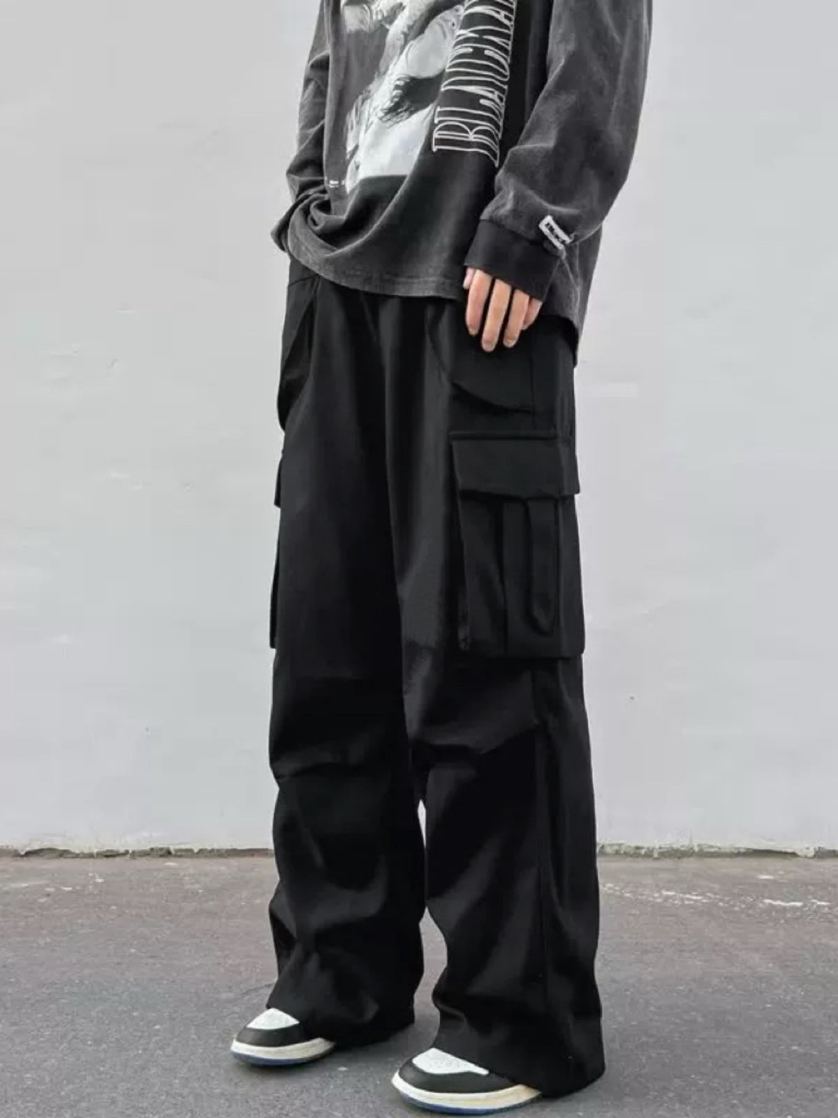 Black wide-leg cargo trousers with large flap side cargo pockets and relaxed fit