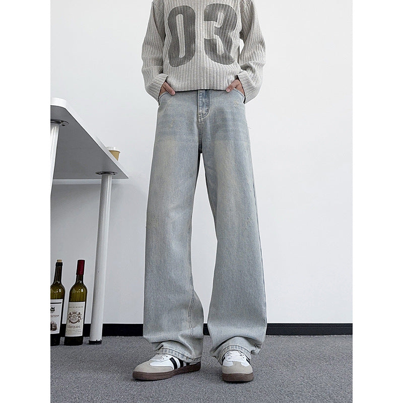 Men's light-wash distressed jeans with relaxed wide legs and faded thigh areas