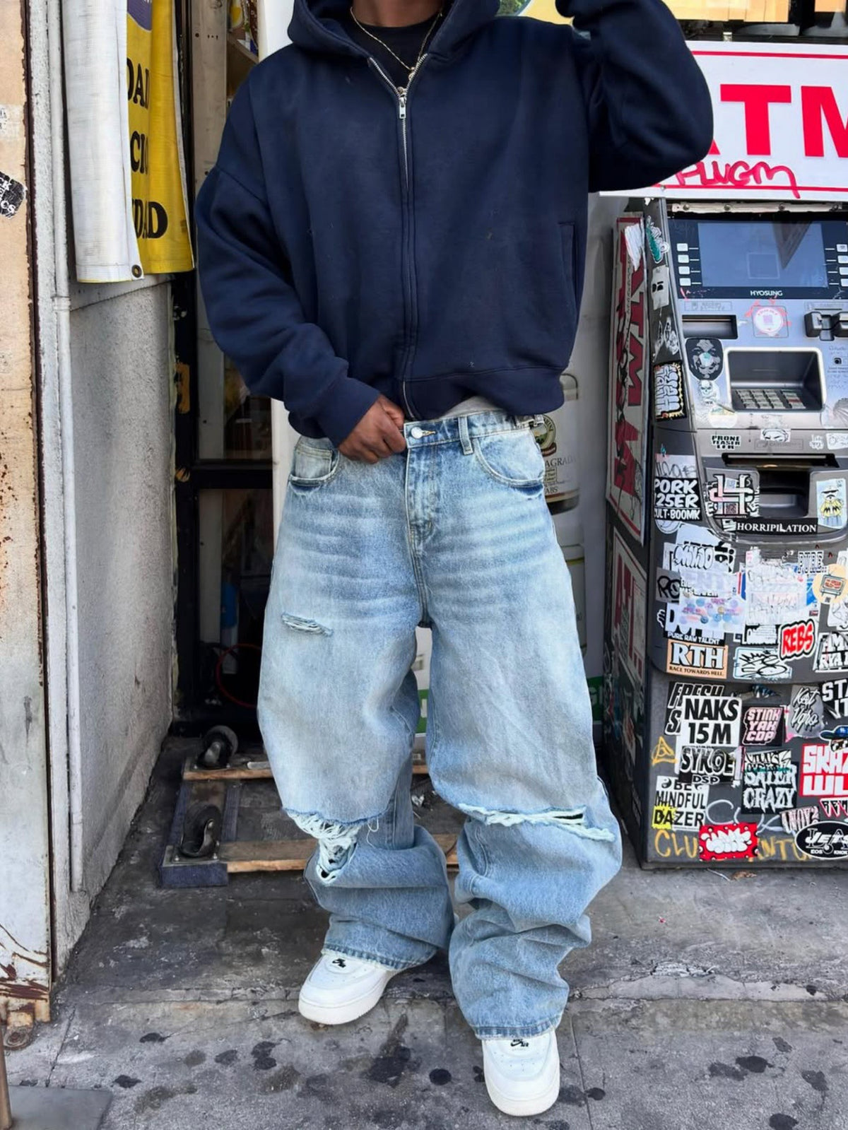 Light-wash ripped men’s jeans with wide cuffs and knee-to-thigh distress