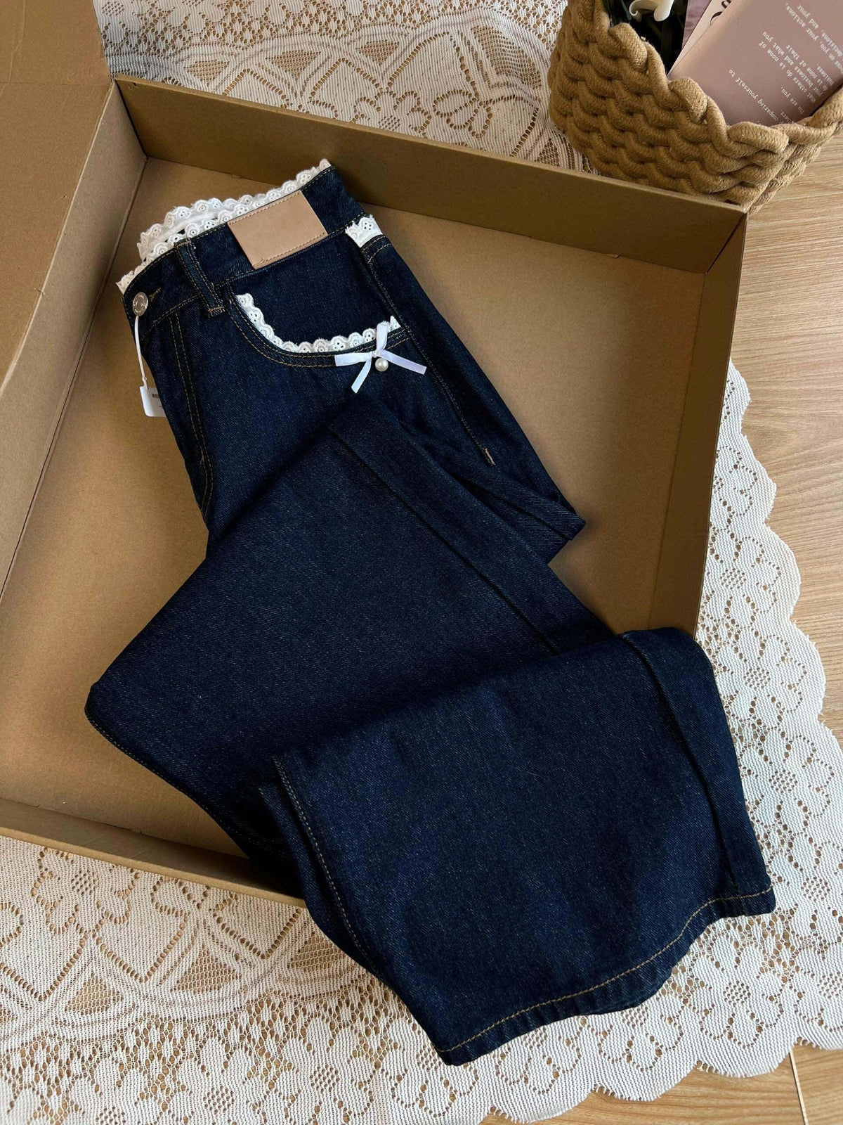 Women’s retro blue denim jeans folded, featuring lace waistband and bow trim