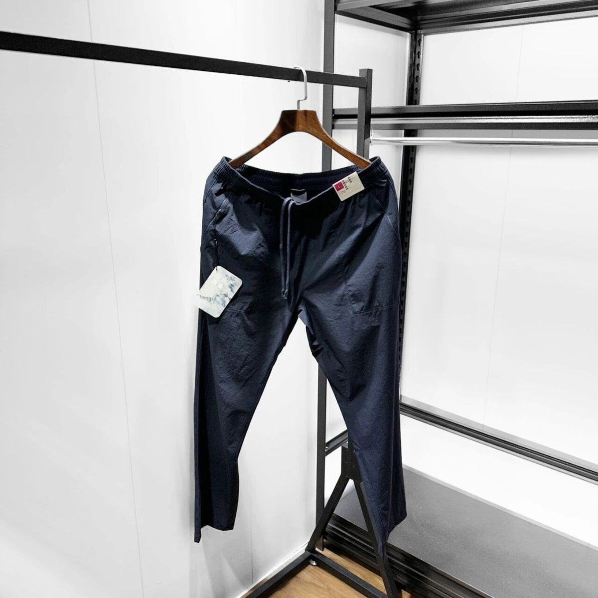Men’s dark navy softshell pants on hanger, elastic waist and drawstring