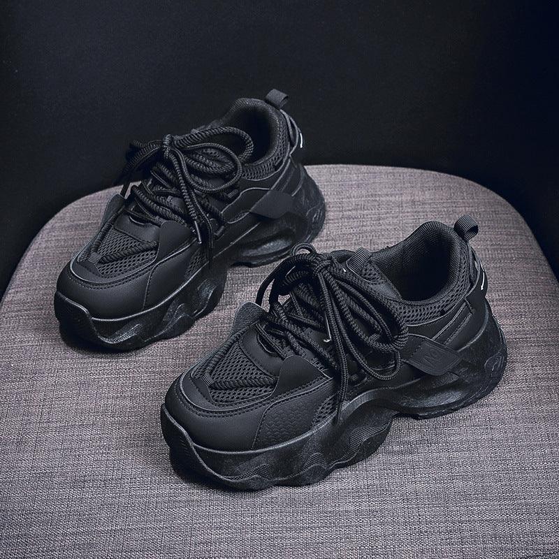 Black dad sneakers with white stitching accents, lace-up top and thick sole