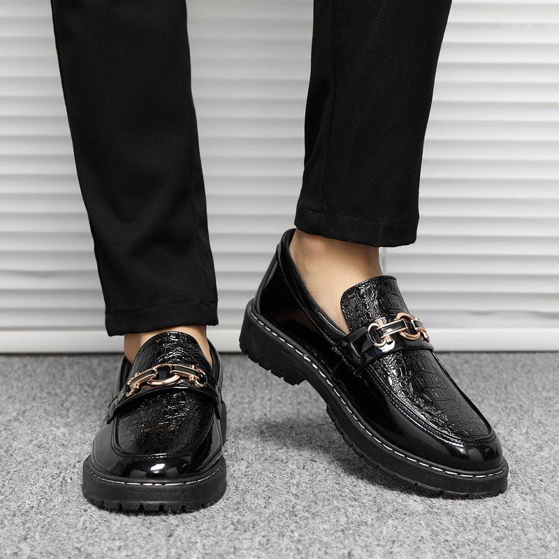 Black glossy leather loafers with metal buckle detail and thick stitched sole.