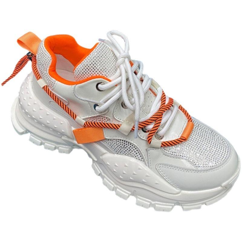 White lace-up platform sneakers with chunky sole and orange ribbon accents