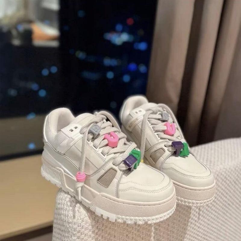 White chunky sneakers with colorful lace charms and thick sole