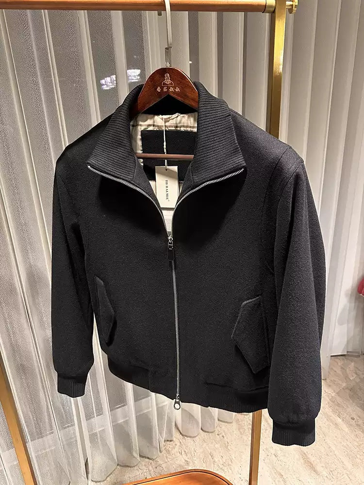 Dark charcoal zip-up wool jacket with stand collar, two flap pockets, ribbed cuffs