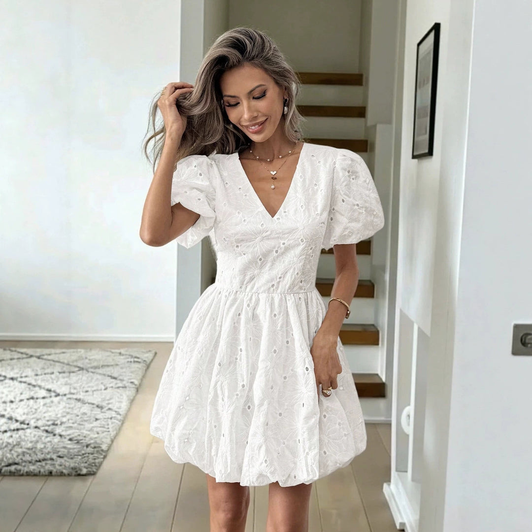 White embroidered mini dress with V-neck, puff sleeves, and gathered waist