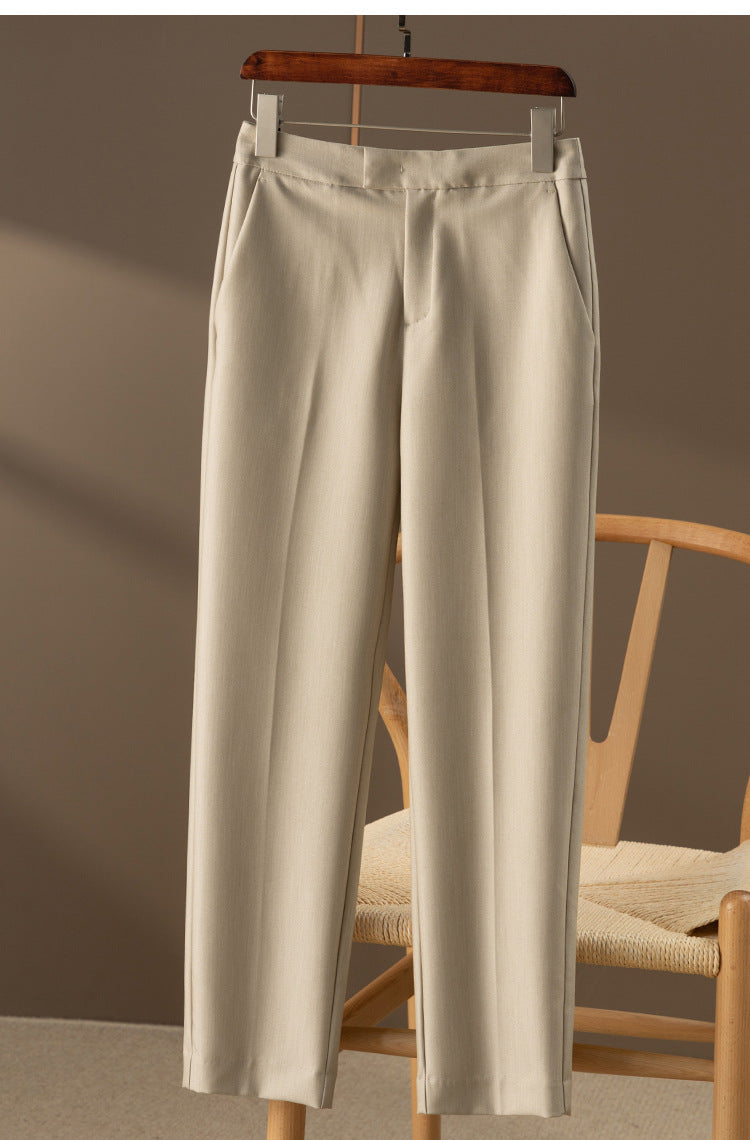 Light beige nine-point tapered dress pants on a hanger with front crease