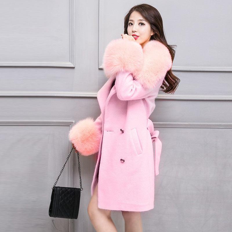 Pink mid-length coat with large fur collar, matching fur cuffs, and tied belt