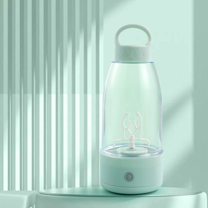 Automatic electric shaker bottle on ledge, mint green base and clear mixing chamber