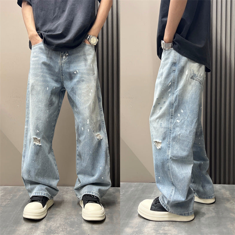 Light blue straight-leg jeans with ripped knees and paint-splatter distress