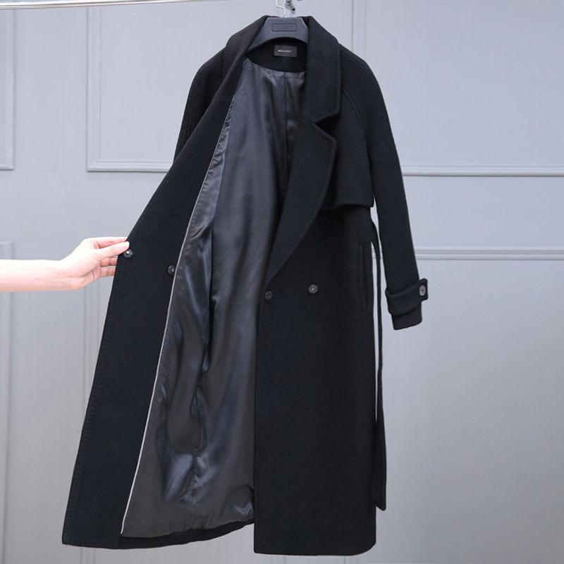Black mid-length wool coat with open front showing quilted lining and sleeve button tab