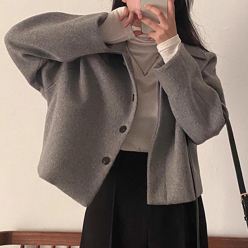 Gray wool short coat with button front, lapels, long sleeves, and flap pockets