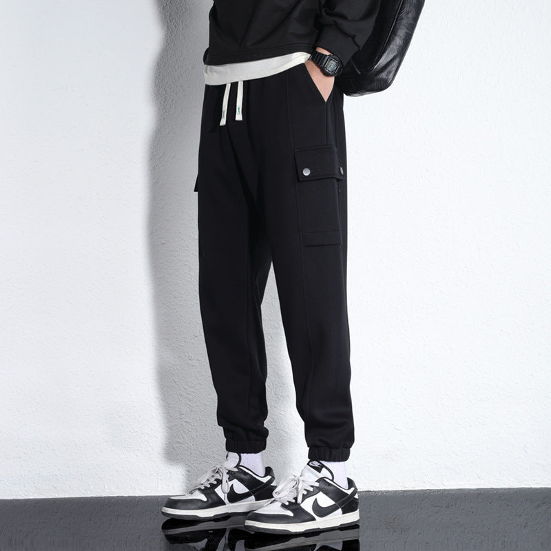 Black cotton cargo jogger trousers with drawstring waist, elastic cuffs, and side flap pocket