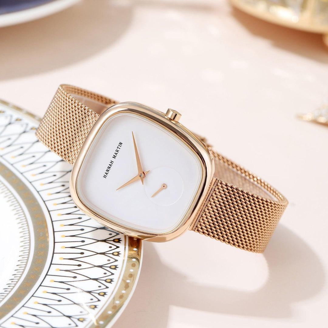 Rose-gold quartz wristwatch with white dial, slim mesh milan band, oval case.