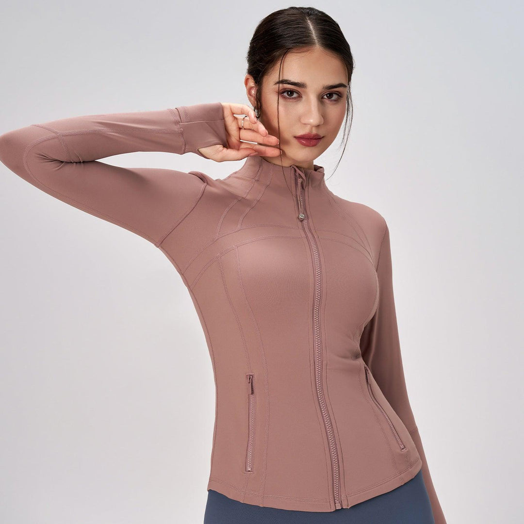 Women's mauve zip-up yoga coat with high neck, full sleeves, and chest zipper pockets