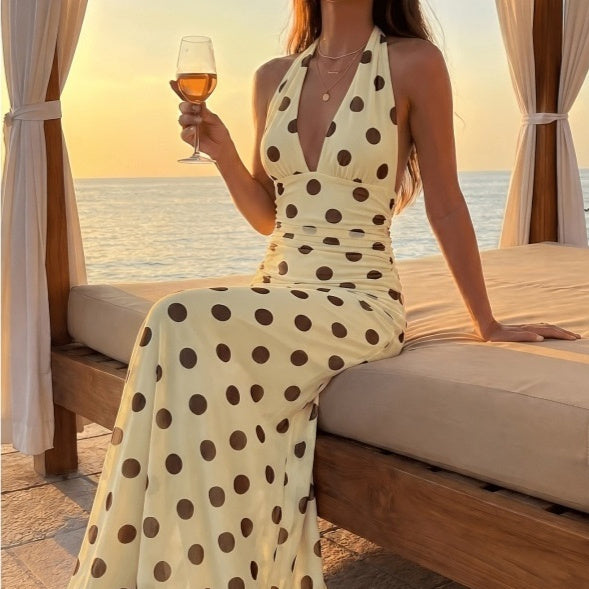 Cream halter-neck maxi dress with dark polka dots; pleated waist, sleeveless.