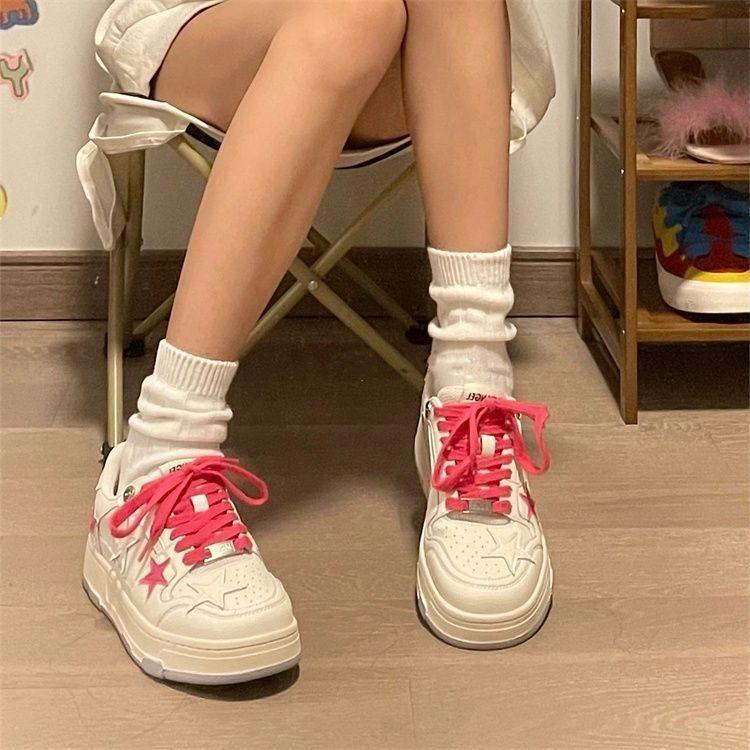 White star-pattern lace-up sneakers with red laces and chunky light sole