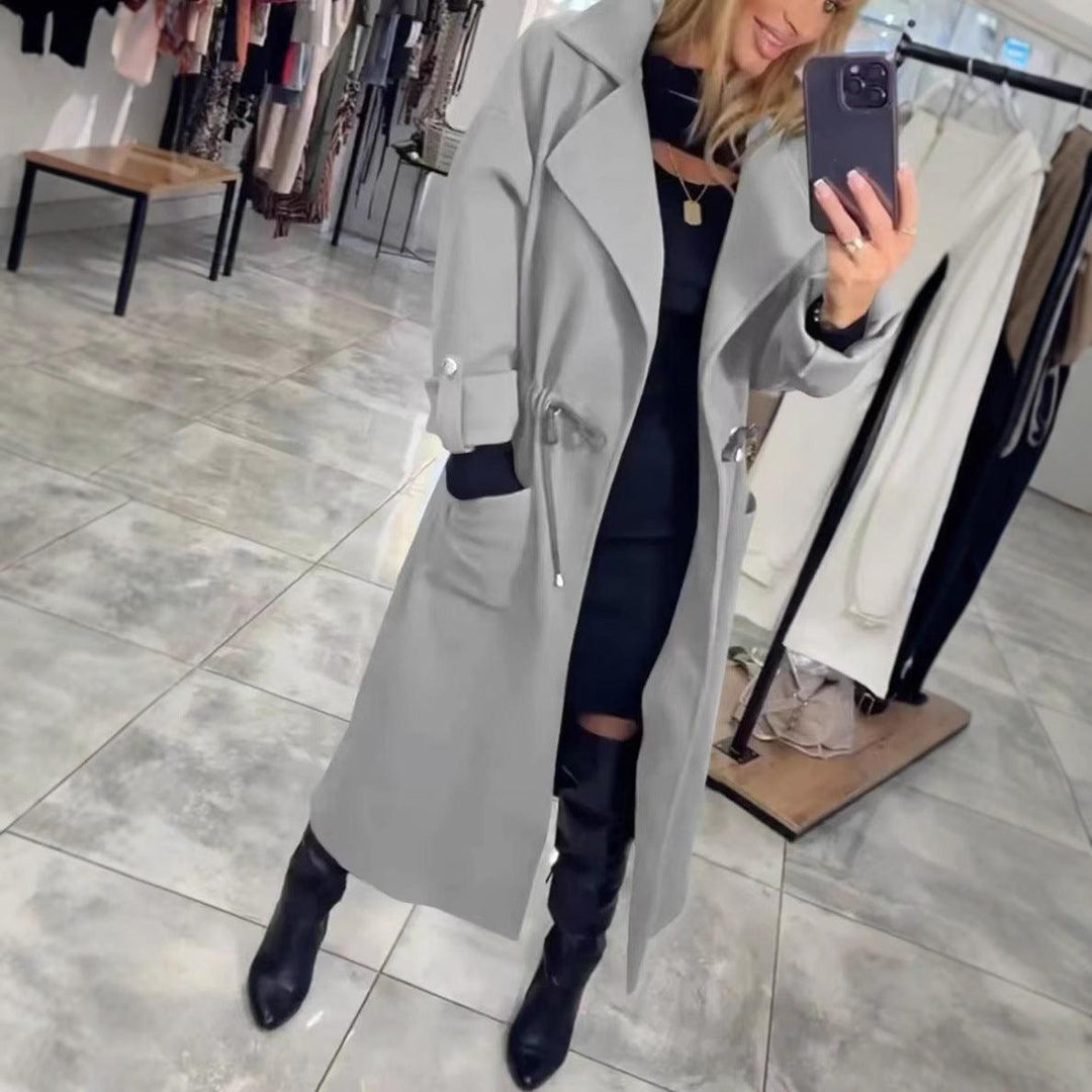 Gray extended-waist trench coat, long sleeves, belt, front flap pockets