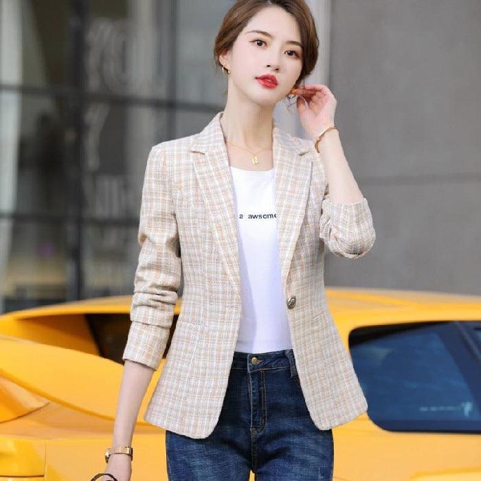 Beige plaid blazer with notched lapels and button front, worn with dark jeans