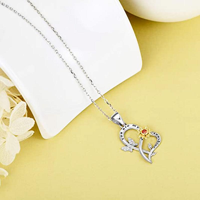 Heart locket pendant necklace with red gem sunflower, silver-tone chain, leaf and butterfly motifs