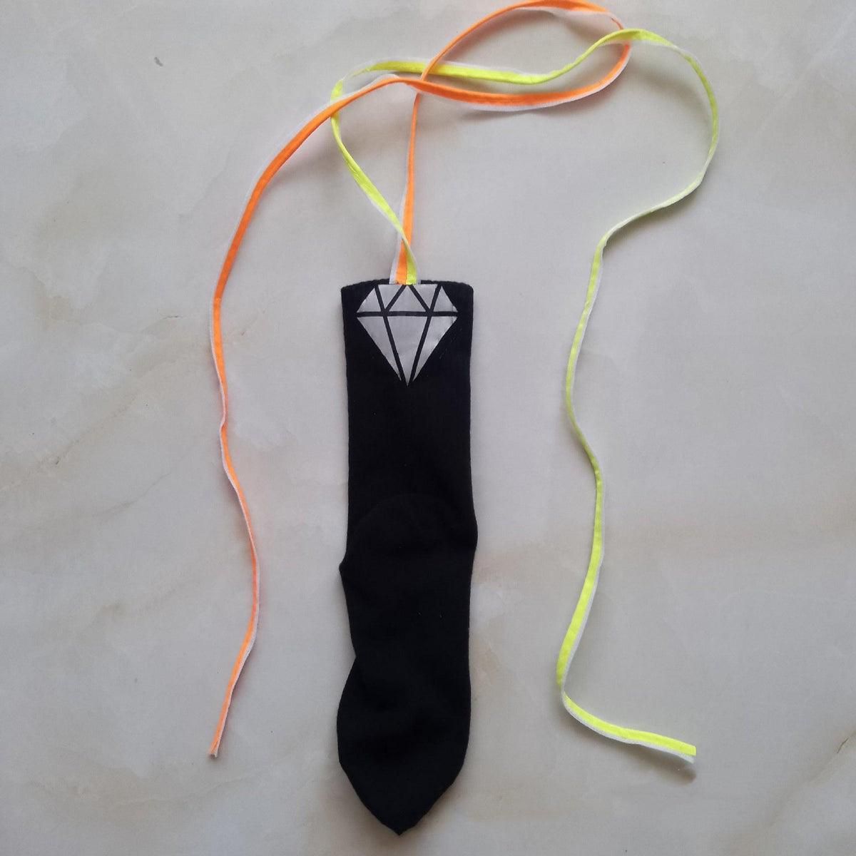 Black sock with orange and neon-green hanging ribbons, gray diamond tag